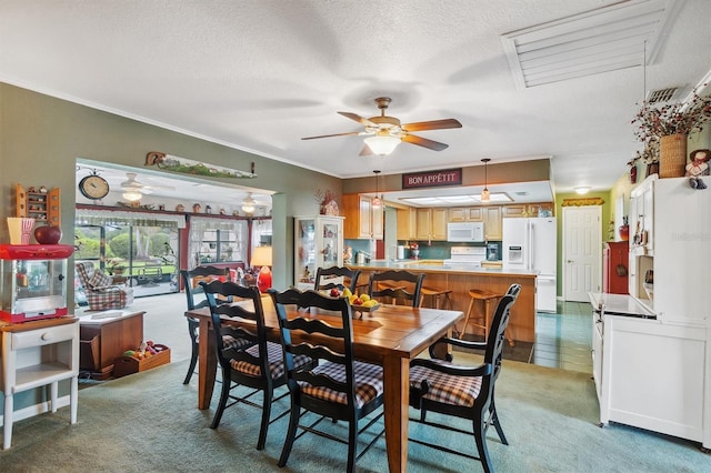 dining area featuring a ceiling fan, visible vents, light carpet, and a textured ceiling