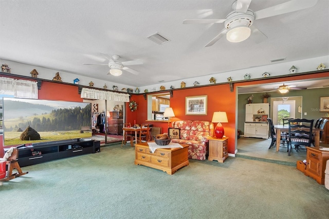 carpeted living room featuring a textured ceiling, visible vents, and a ceiling fan