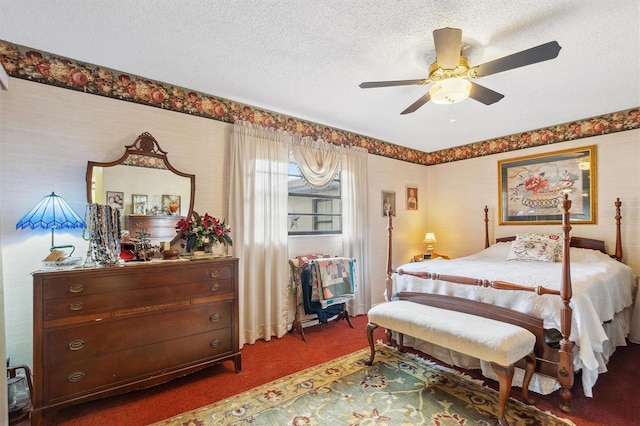 carpeted bedroom with a textured ceiling, wallpapered walls, and ceiling fan
