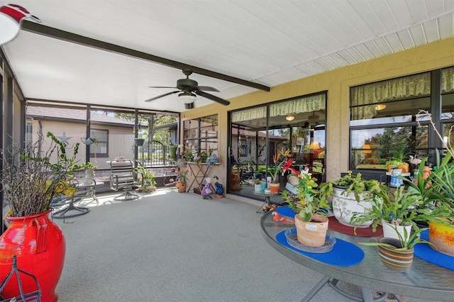 sunroom with beam ceiling and ceiling fan