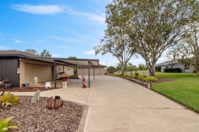 view of side of property featuring an attached garage, concrete driveway, and a yard