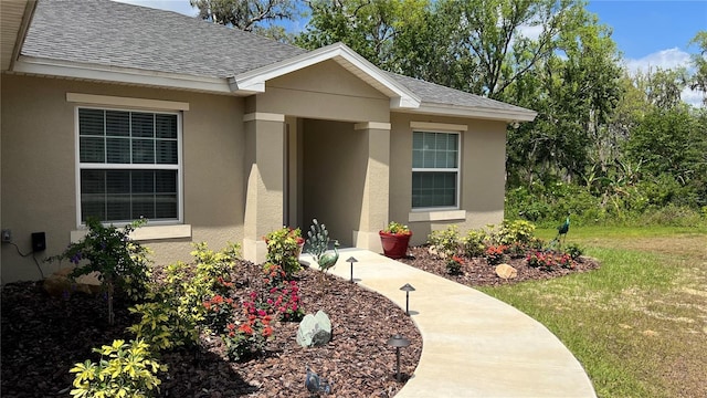214 Brook Ln, Polk City, FL 33868 - property entrance featuring stucco siding and a shingled roof