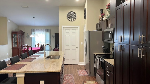 214 Brook Ln, Polk City, FL 33868 - kitchen featuring a kitchen breakfast bar, stainless steel microwave, a sink, an island with sink, and range with electric stovetop