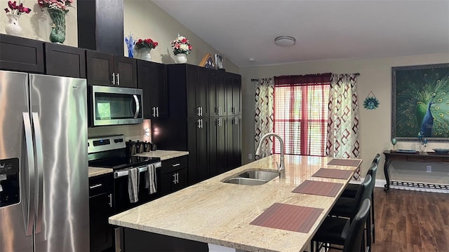 214 Brook Ln, Polk City, FL 33868 - kitchen featuring stainless steel appliances, a sink, dark wood-style floors, a kitchen island with sink, and dark cabinets