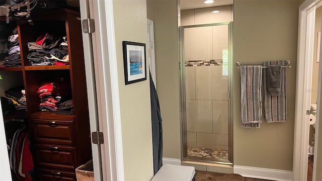 214 Brook Ln, Polk City, FL 33868 - bathroom with a walk in closet, a stall shower, baseboards, and recessed lighting