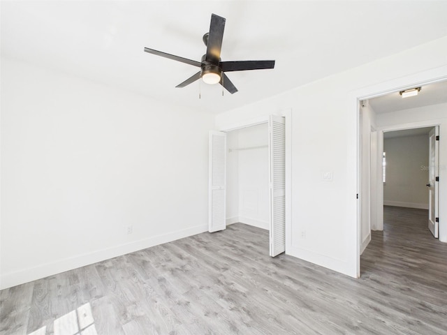 unfurnished bedroom with a closet, baseboards, ceiling fan, and wood finished floors