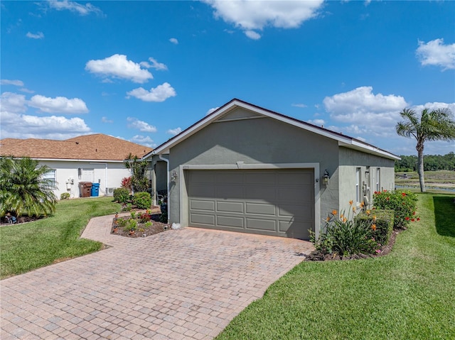 exterior space featuring stucco siding, driveway, an attached garage, and a front yard