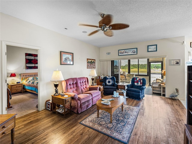 living room featuring a textured ceiling, wood finished floors, and a ceiling fan