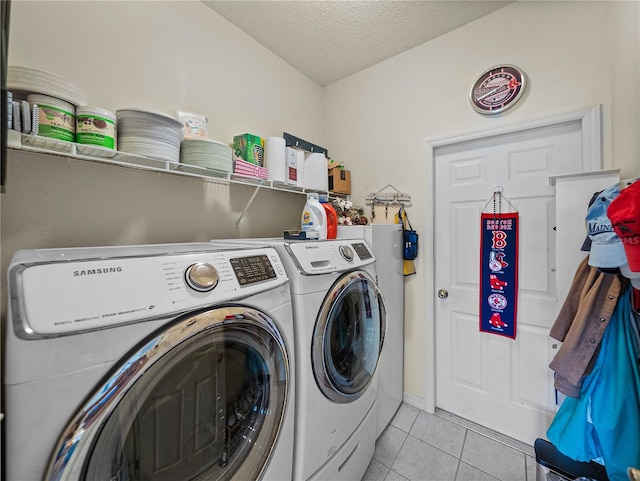 laundry room with a textured ceiling, separate washer and dryer, laundry area, and light tile patterned floors