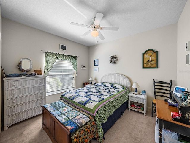 bedroom featuring a textured ceiling, a ceiling fan, and carpet