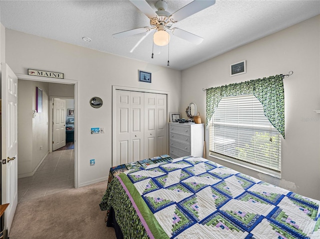 bedroom with a closet, a textured ceiling, baseboards, ceiling fan, and light colored carpet