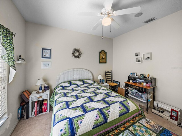 carpeted bedroom with visible vents and a ceiling fan