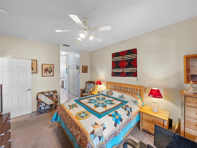 carpeted bedroom featuring a closet, ensuite bath, ceiling fan, and visible vents