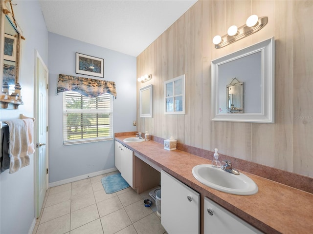 bathroom with tile patterned floors, double vanity, a sink, and baseboards