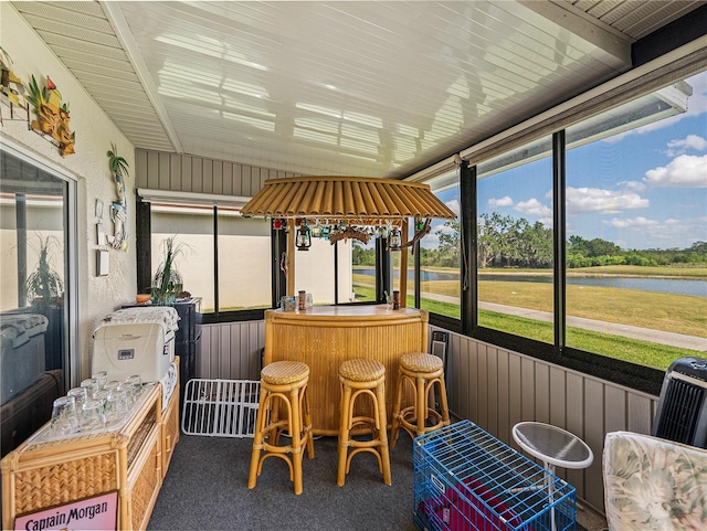 sunroom / solarium featuring a water view