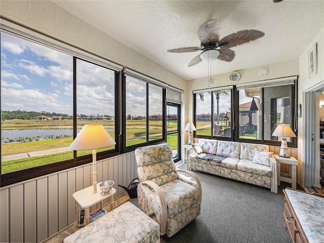 sunroom featuring a water view and ceiling fan