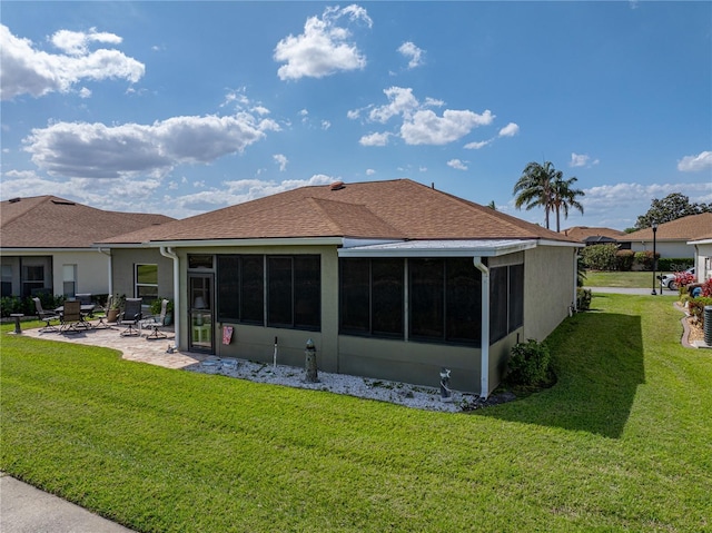 rear view of house featuring a patio, a sunroom, stucco siding, and a yard
