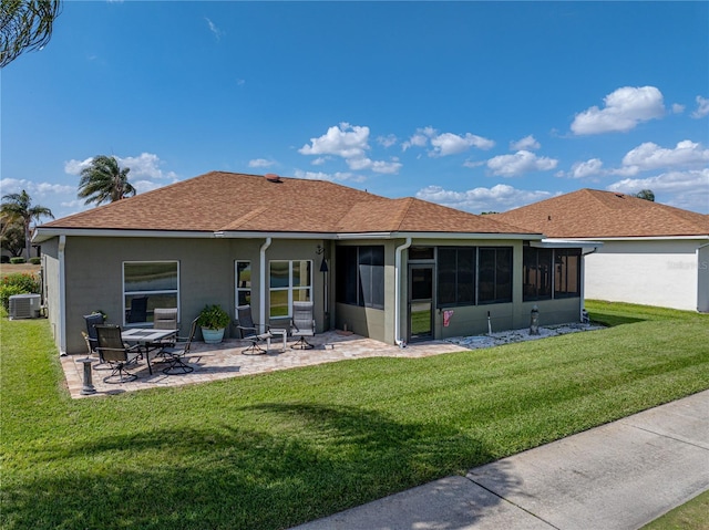 rear view of house featuring a lawn, a sunroom, central air condition unit, and a patio area