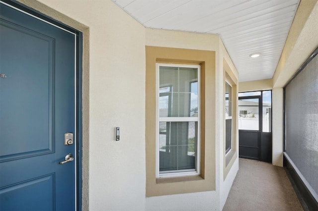 doorway to property featuring stucco siding