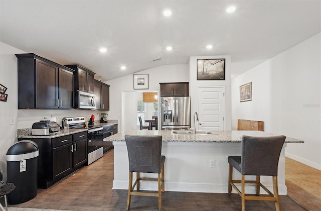 kitchen featuring a sink, a breakfast bar, an island with sink, and appliances with stainless steel finishes