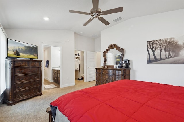 bedroom featuring visible vents, vaulted ceiling, a walk in closet, and light carpet
