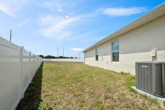 view of yard featuring a fenced backyard and central AC