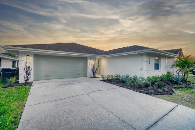 view of front of house with an attached garage, driveway, and stucco siding