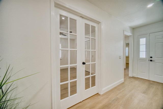 entrance foyer with baseboards, french doors, and wood finished floors