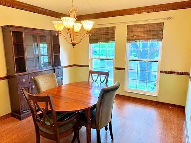 2761 Graniteridge Ct, Orange Park, FL 32065 - dining area featuring a chandelier, wood finished floors, and baseboards