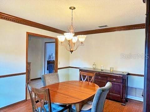 2761 Graniteridge Ct, Orange Park, FL 32065 - dining area featuring a chandelier, crown molding, baseboards, and light wood-style flooring