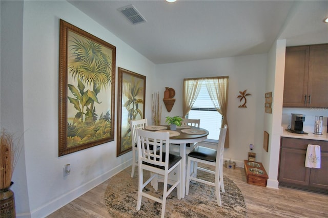 dining space with visible vents, baseboards, and light wood-style flooring