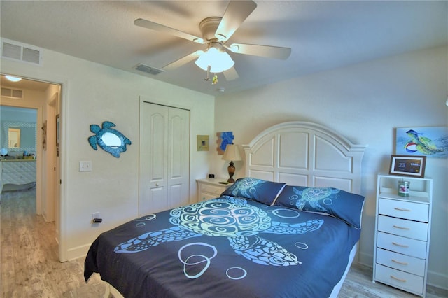 bedroom featuring visible vents, light wood-type flooring, and a closet