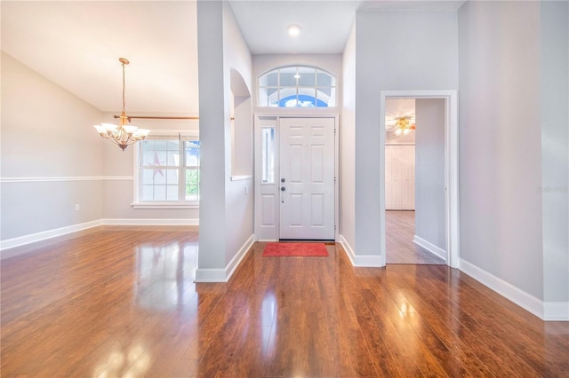 entryway featuring a notable chandelier, baseboards, and wood finished floors
