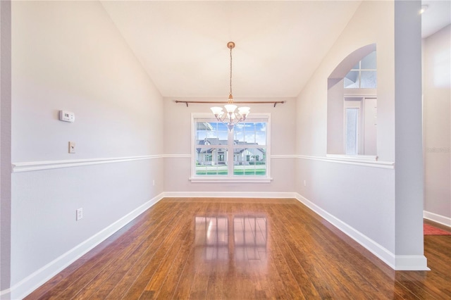unfurnished dining area with baseboards, an inviting chandelier, and hardwood / wood-style floors
