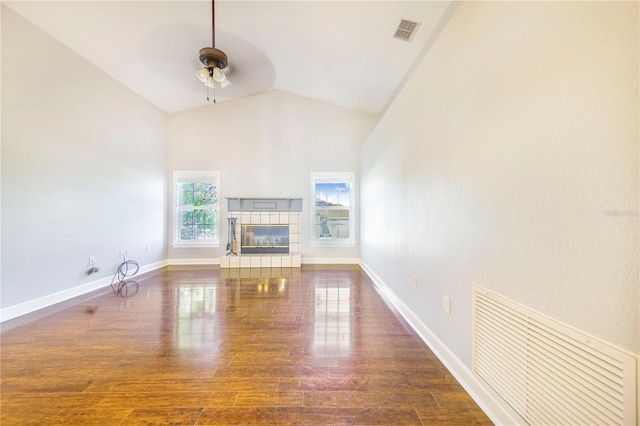 unfurnished living room featuring a fireplace, a ceiling fan, visible vents, wood finished floors, and baseboards