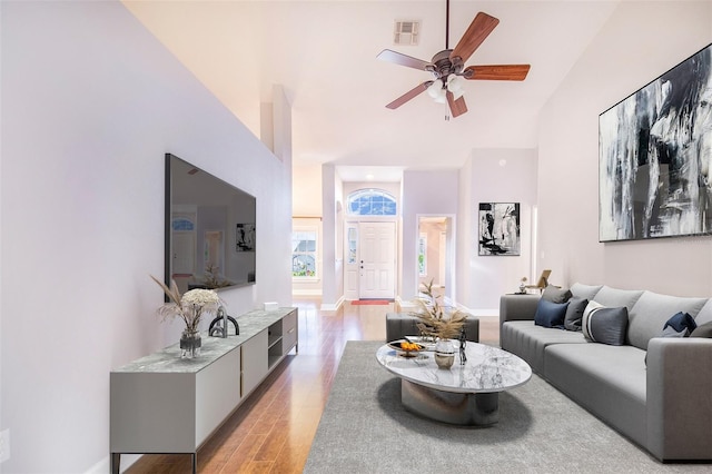 living room with visible vents, high vaulted ceiling, light wood finished floors, and a ceiling fan