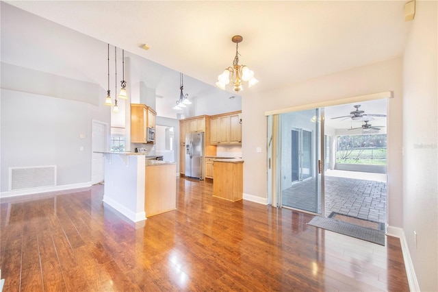 kitchen with appliances with stainless steel finishes, wood finished floors, light brown cabinets, and visible vents