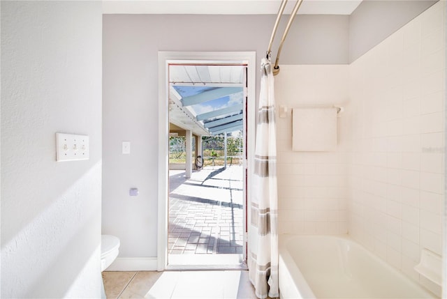 full bath featuring toilet, shower / tub combo with curtain, baseboards, and tile patterned flooring