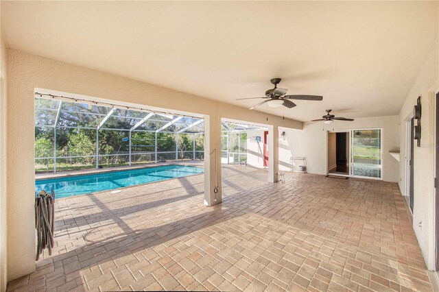 outdoor pool featuring a lanai, a patio area, and a ceiling fan