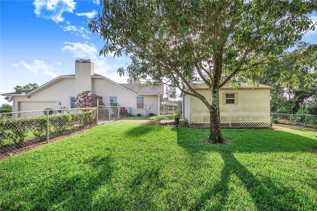 back of property featuring a garage, a fenced backyard, an outdoor structure, and a lawn
