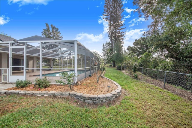 view of yard featuring a fenced in pool, fence, and glass enclosure