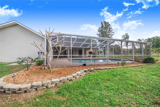 rear view of property featuring stucco siding, an outdoor pool, a patio area, a yard, and glass enclosure