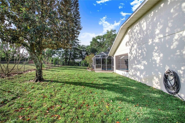 view of yard featuring fence and a lanai