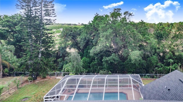 outdoor pool featuring fence and glass enclosure