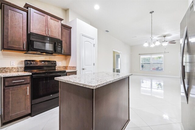 404 Rio Grande Ct, Poinciana, FL 34759 - kitchen featuring dark brown cabinets, black appliances, a kitchen island, and light stone counters