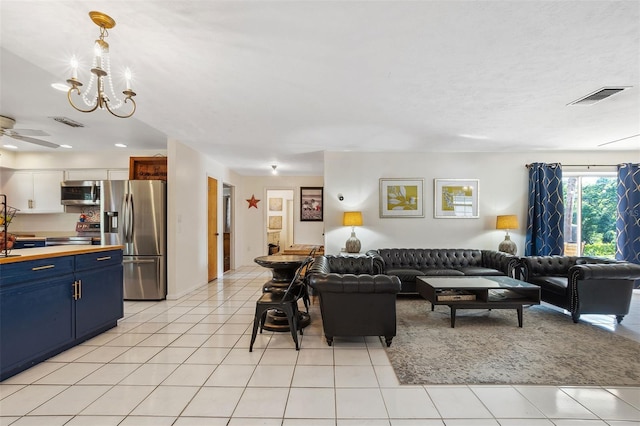 102 Lake Ring Dr, Winter Haven, FL 33884 - living area featuring ceiling fan with notable chandelier, light tile patterned floors, and visible vents