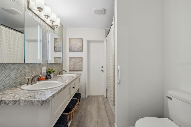 102 Lake Ring Dr, Winter Haven, FL 33884 - full bathroom with decorative backsplash, a sink, toilet, and wood finished floors