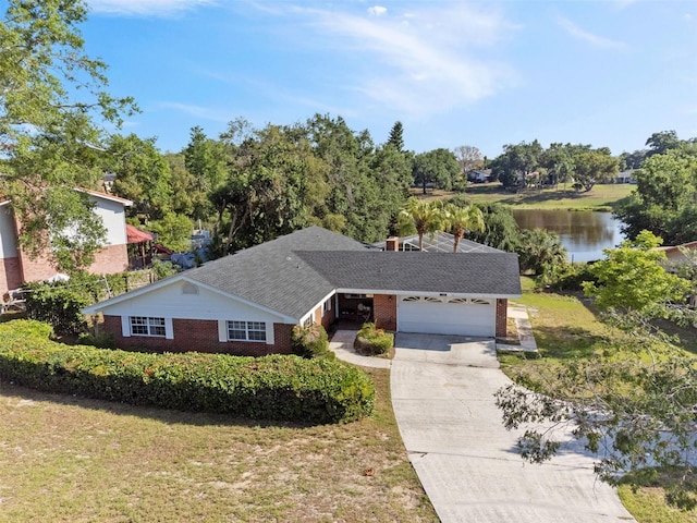 102 Lake Ring Dr, Winter Haven, FL 33884 - single story home with a garage, a water view, a front lawn, brick siding, and concrete driveway