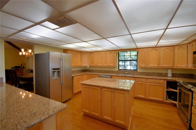 2611 State Road 557, Lake Alfred, FL 33850 - kitchen with light brown cabinetry, appliances with stainless steel finishes, light stone counters, a sink, and light wood finished floors
