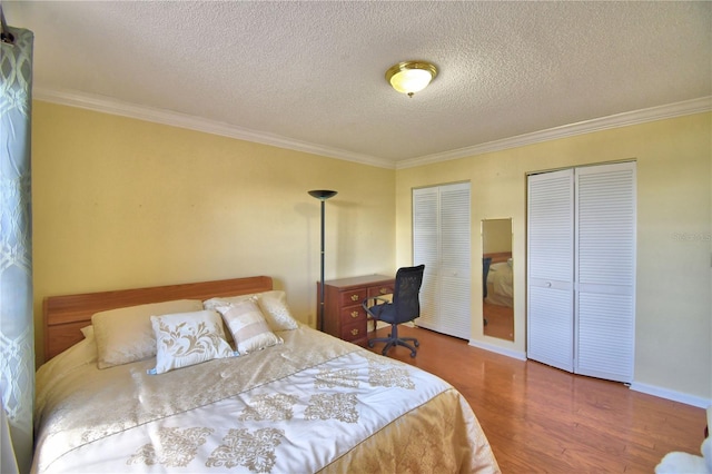 2611 State Road 557, Lake Alfred, FL 33850 - bedroom featuring a textured ceiling, two closets, ornamental molding, and wood finished floors